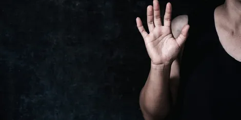Raised hand in a dark room, sex crimes defense